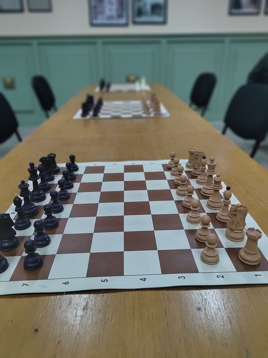 Šahovske table na dugom stolu u klupskoj prostoriji