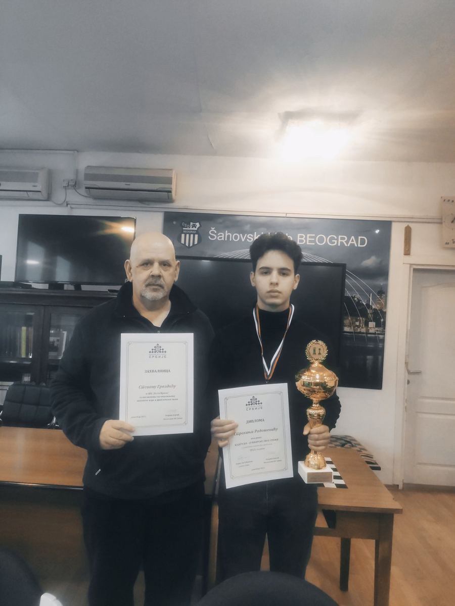 Trener i mladi šahista sa diplomama i pehara posle turnira